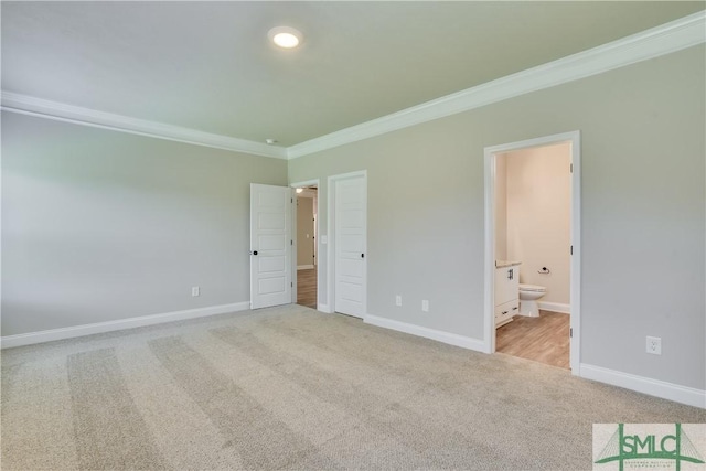 unfurnished bedroom featuring baseboards, carpet flooring, connected bathroom, and crown molding