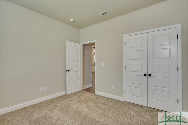 unfurnished bedroom featuring visible vents, a closet, baseboards, and carpet flooring