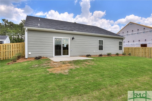 back of property with a yard, a patio, and fence