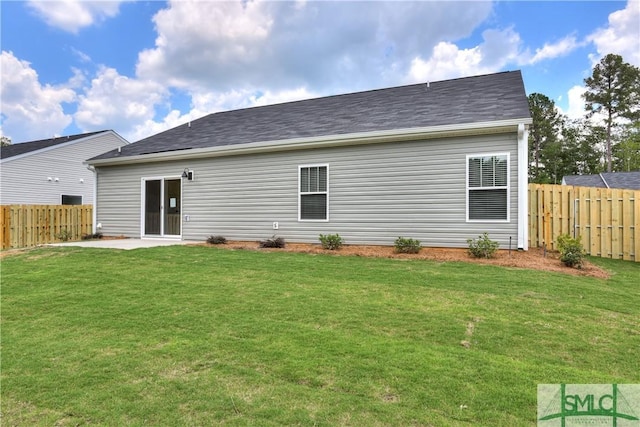 rear view of house with a fenced backyard, a patio, and a yard