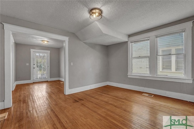 foyer with wood-type flooring, baseboards, and a textured ceiling