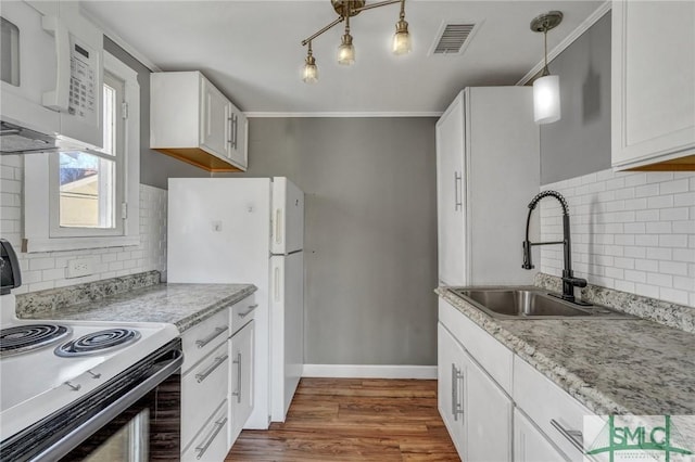 kitchen featuring white appliances, baseboards, visible vents, dark wood finished floors, and a sink