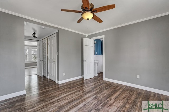 unfurnished room with crown molding, baseboards, and dark wood-style flooring