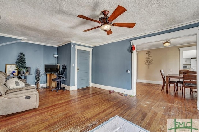 living room featuring ornamental molding, a ceiling fan, hardwood / wood-style flooring, and baseboards