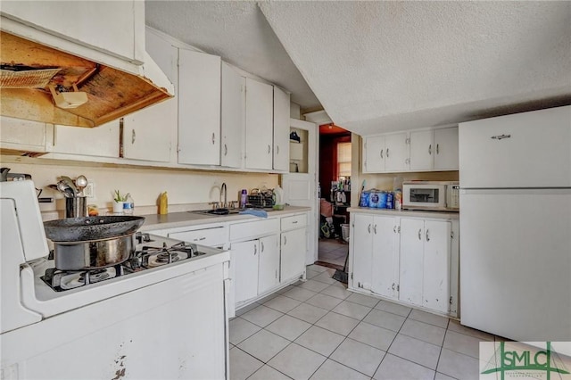 kitchen featuring white cabinets, white appliances, light tile patterned floors, and light countertops