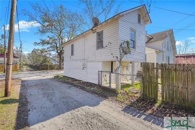 view of home's exterior featuring fence and driveway