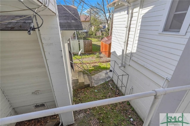 view of side of home featuring crawl space and fence