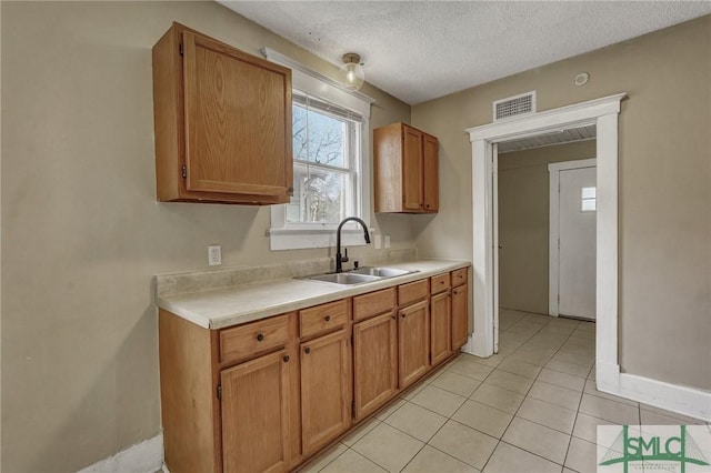 kitchen featuring light countertops, visible vents, a sink, and a textured ceiling