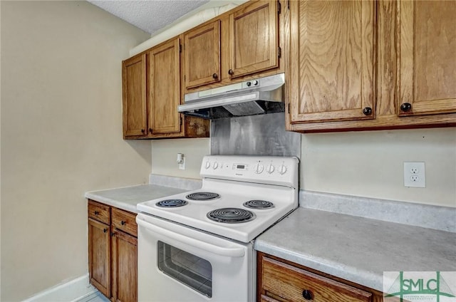 kitchen featuring brown cabinets, light countertops, a textured ceiling, white electric range, and under cabinet range hood