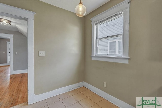 empty room featuring light tile patterned floors and baseboards