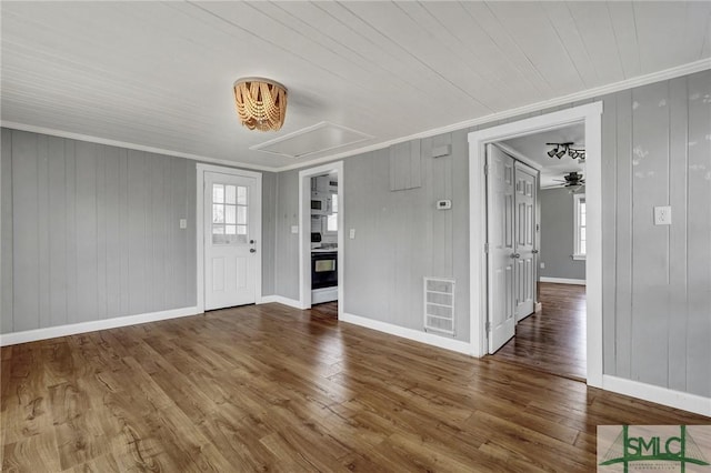 interior space featuring baseboards, crown molding, visible vents, and wood finished floors