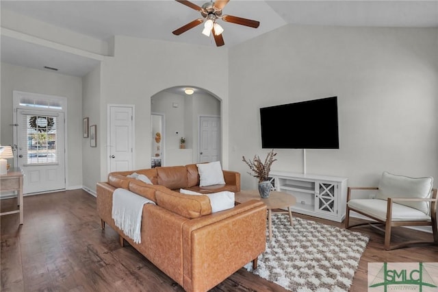 living area with ceiling fan, arched walkways, vaulted ceiling, and wood finished floors