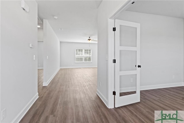 hallway with wood finished floors and baseboards