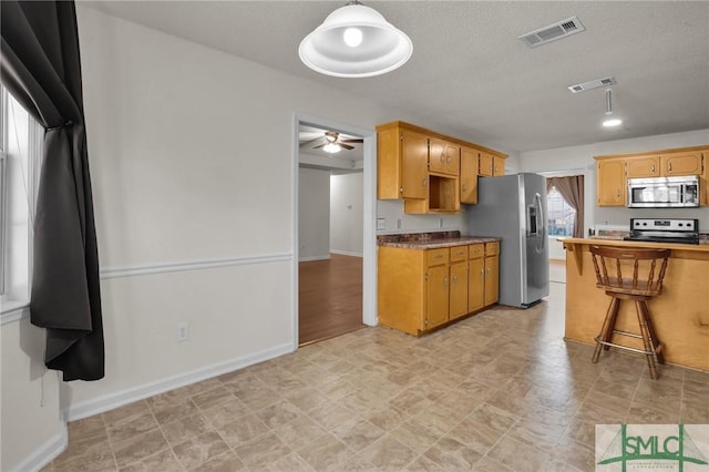 kitchen with appliances with stainless steel finishes, visible vents, and a textured ceiling