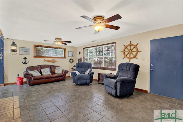 living room with visible vents, ceiling fan, and baseboards