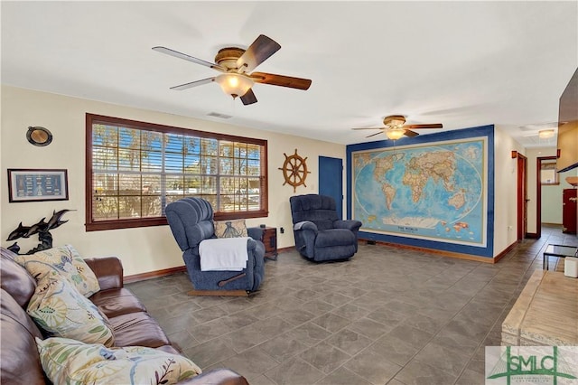 living area featuring baseboards, visible vents, and a ceiling fan