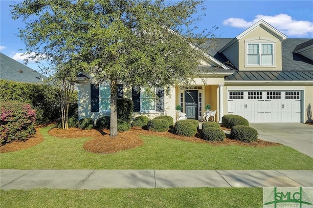 view of front of house with driveway, a standing seam roof, metal roof, and a front yard