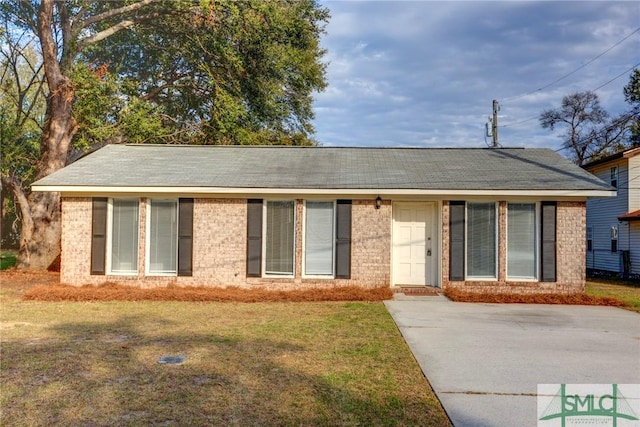 single story home with brick siding and a front yard