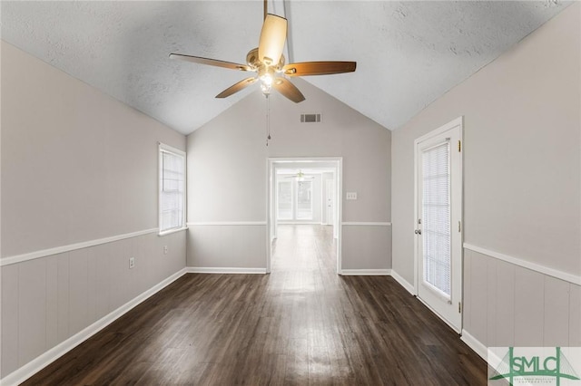 empty room featuring a wainscoted wall, a textured ceiling, wood finished floors, and visible vents