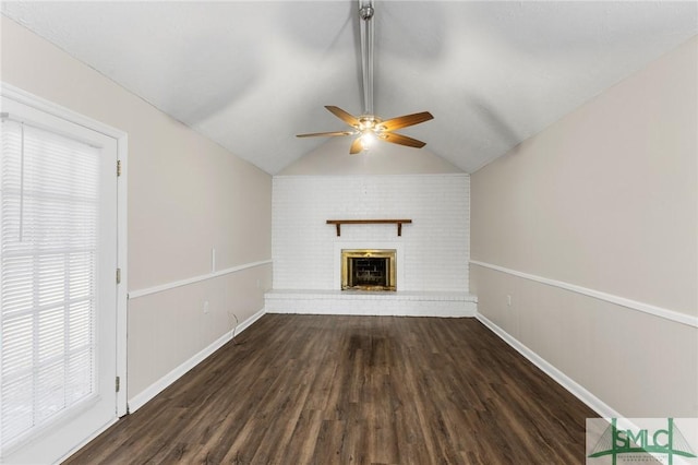 unfurnished living room with lofted ceiling with beams, wood finished floors, a ceiling fan, baseboards, and a brick fireplace