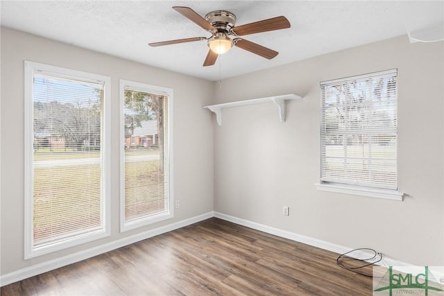 spare room with a ceiling fan, a textured ceiling, baseboards, and wood finished floors