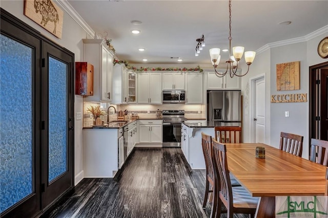 kitchen featuring appliances with stainless steel finishes, dark countertops, glass insert cabinets, and crown molding