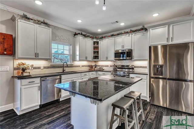 kitchen with stainless steel appliances, dark wood-style flooring, a sink, and visible vents