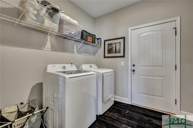 washroom featuring washing machine and dryer, laundry area, dark wood finished floors, and baseboards