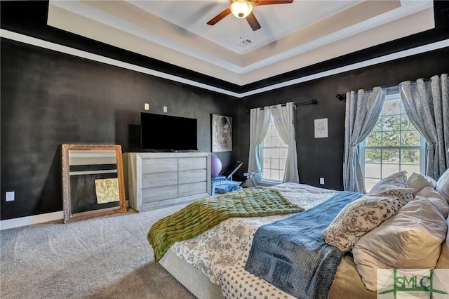 bedroom featuring carpet floors, a raised ceiling, visible vents, and baseboards