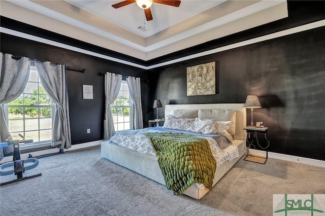 carpeted bedroom with ceiling fan and baseboards