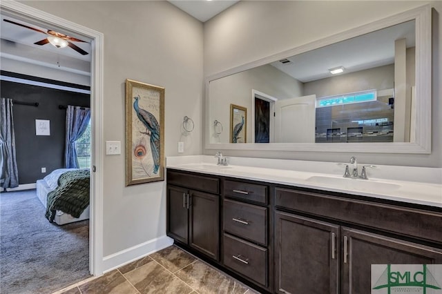 bathroom featuring baseboards, a sink, ensuite bath, and double vanity