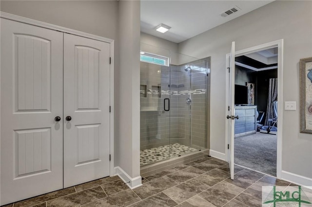 bathroom featuring a shower stall, visible vents, and baseboards