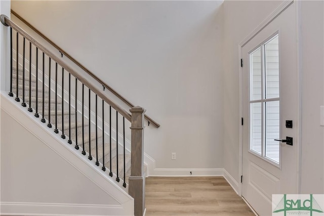 foyer featuring light wood-style floors, stairway, and baseboards