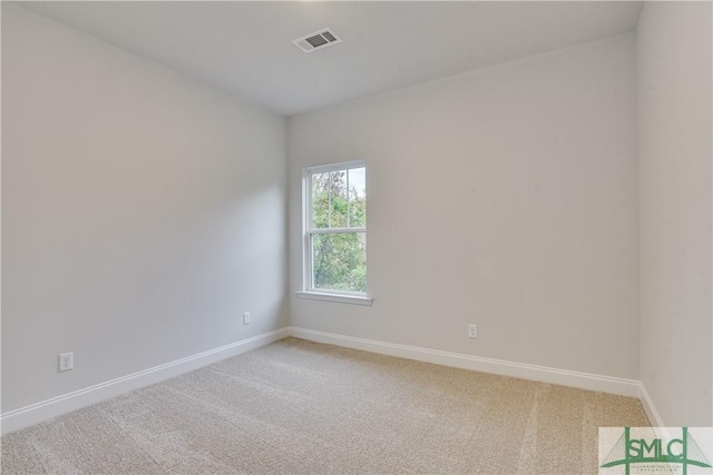 empty room with visible vents, light carpet, and baseboards