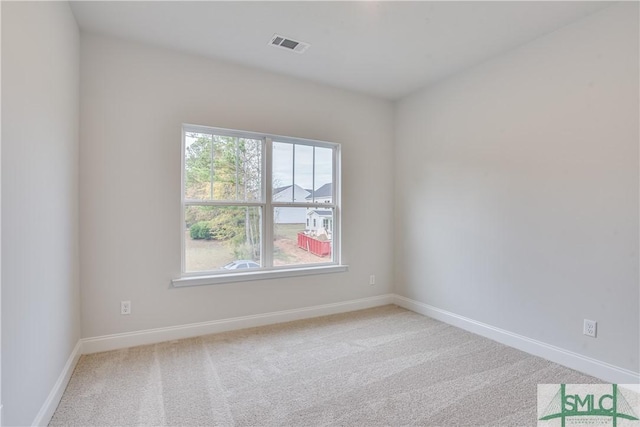 carpeted spare room featuring visible vents and baseboards