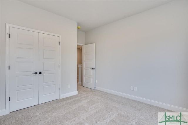 unfurnished bedroom with carpet floors, a closet, and baseboards