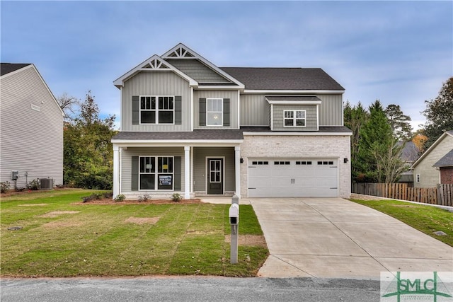 craftsman-style home featuring an attached garage, board and batten siding, a front yard, fence, and driveway