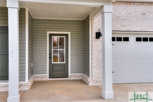 property entrance with a garage and stone siding