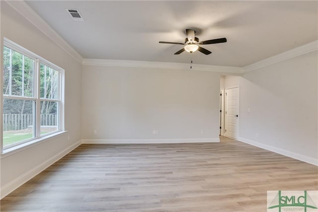 empty room with light wood-style floors, visible vents, baseboards, and crown molding