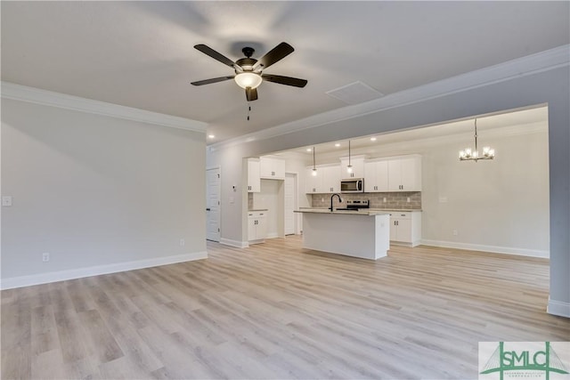 unfurnished living room with light wood finished floors, ornamental molding, ceiling fan with notable chandelier, and baseboards