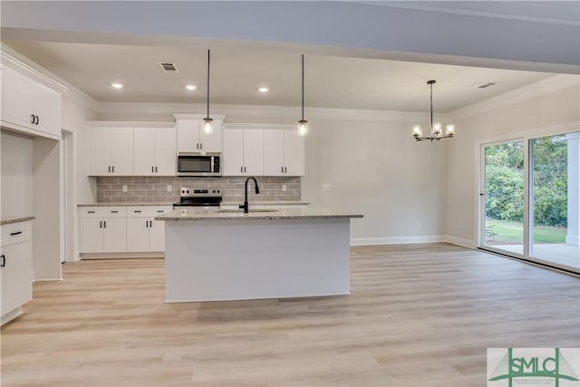 kitchen with appliances with stainless steel finishes, a sink, white cabinets, and crown molding