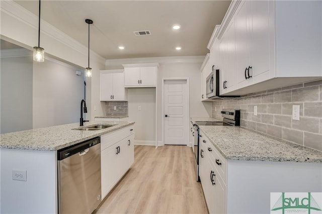 kitchen with visible vents, appliances with stainless steel finishes, ornamental molding, white cabinets, and a sink