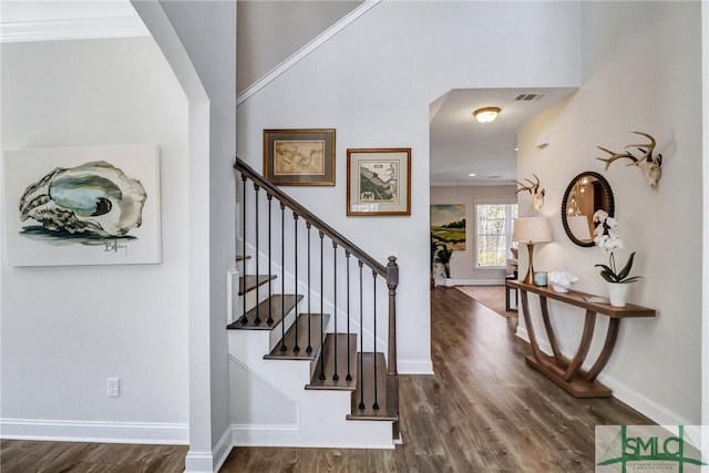 foyer featuring baseboards, visible vents, and wood finished floors