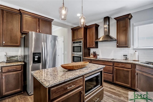 kitchen featuring a toaster, crown molding, appliances with stainless steel finishes, wall chimney range hood, and wood finished floors