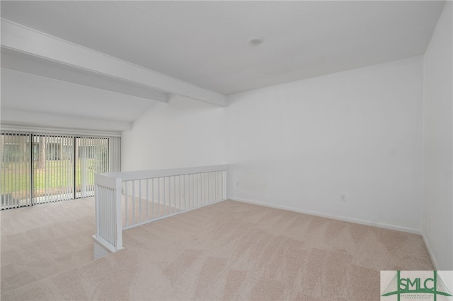 spare room featuring carpet floors, lofted ceiling with beams, and baseboards