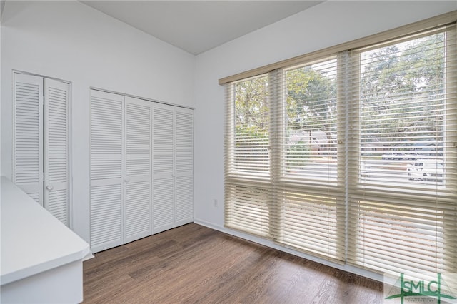 unfurnished bedroom with two closets and wood finished floors