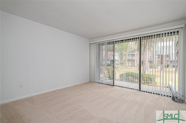 carpeted empty room featuring a healthy amount of sunlight and baseboards