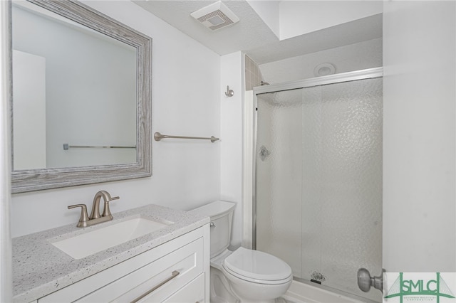 full bathroom featuring a stall shower, visible vents, vanity, and toilet