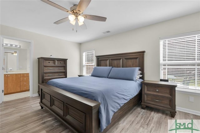 bedroom with ceiling fan, connected bathroom, visible vents, baseboards, and light wood finished floors