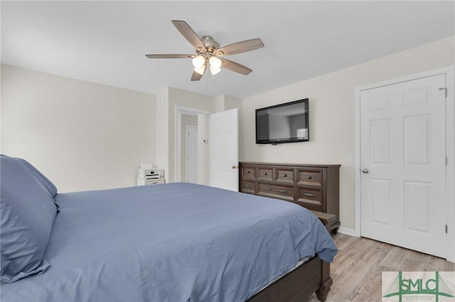 bedroom featuring ceiling fan, light wood finished floors, and baseboards